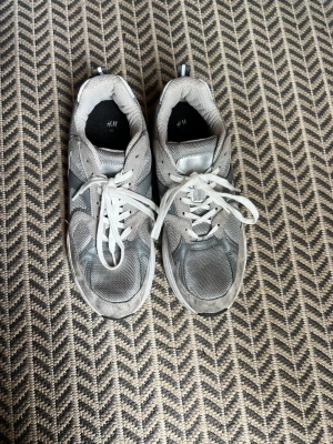 Gråa sneakers  - Använt 2-3 gånger. Något små i storleken. Fläckarna borde gå bort lätt. Jag kan prova maskintvätta dem om så önskas efter köp men det riskerar slitage.