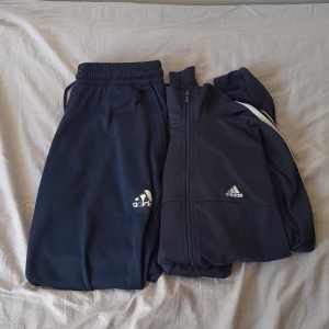 Three striped adidas  - Har använts i ett tag men det syns inte alls på klädera. Kommer med både kofta och byxa. Är mörkblå. Priset kan diskuteras i privat.