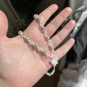 Halsband - Ett grönt halsband med en fjärilsberlock som jag har gjort själv!🦋🌿Man kan reglera längden (bild 3) och den passar perfekt nu till sommaren☀️Om du vill se fler bilder och eller har frågor så är det bara att skriva till mig!🫶🏻Köparen står för frakten.