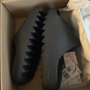 YEEZY SLIDES - Helt nya Yeezy Slides Onyx i storlek 40,5. Säljer pga fel storlek för mig. Kvitto finns! Eventuell frakt betalas av köparen 🌞