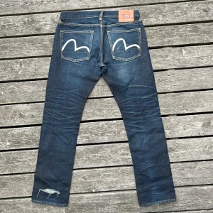 EVISU - VINTAGE JEANS - - Fint vintage skick med schysst patina - Size 33 med slim straight passform - Hål över vänster bensluts baksida - 2 Early 2000s vibes 