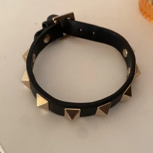 Valentino armband - Hej! Jag säljer detta valentino armband eftersom det inte kommer till andvändning längre. Det är i färgen guld och svart och det är bara andvänt 4-5 ggr.