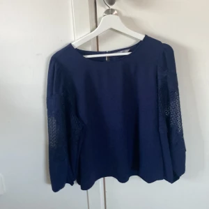 Blå blus med genomskinligt spets på armarna  - Jätte fin Dam blus med puffiga armar i stl XL. Den är i bra skick. Säljer eftersom den inte kommit till andvänding.