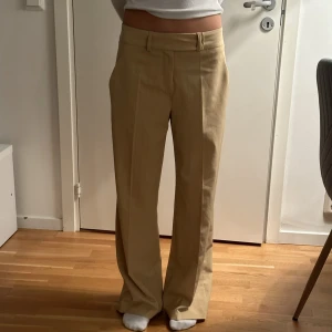 Randiga kostymbyxor - Coola kostymbyxor från second hand, sitter lågmidjade och snyggt oversize på mig som är 167 och brukar ha storlek 34. De är ljusbruna/beiga med tunna röda streck. Skriv för fler bilder🫶🏻