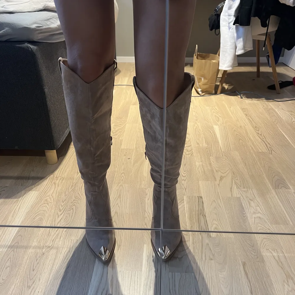 Super fina boots i en mörk beige färg och en gulddetalj, till knäna på mig som är 170 cm! Fick hem de idag därav aldrig använda, tänkte kolla om någon är intresserad annars skickas de tillbaka. Nypris 990! ❤️‍🔥❤️‍🔥. Skor.