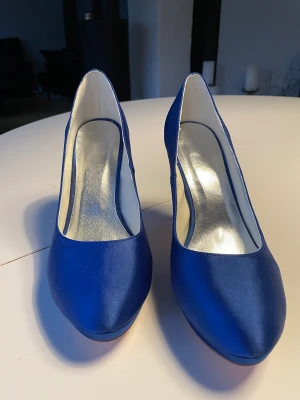 Kornblå sko i satäng  - Kornblå sko med stilettklack. Bara testade hemma i vardagsrummet en gång. Nypris 914 kr 
