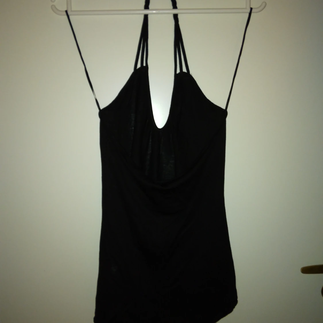 Svart oanvänd topp / linne. Flätat band i nacken, knyt nedtill. Strlk: XS-SMALL. Bomull  viskos. Felfri. - 1