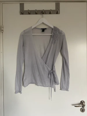 Jättesöt kofta/topp med blommor  - Söt kofta med blommor och knytning framtill, tunnt material. Den är lite nopprig men inget som syns tydligt.