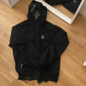 Haglöfs Chaos GTX Jacket Men size M - Skaljacka från haglöfs i mycket bra skick som använts varsamt, inga slitningar eller hål osv. I modellen ”Chaos GTX Jacket Men” storlek M. Handfickor på varje sida. Spännen vid midja och luva för att justera bredd/tajthet. Goretex! Originalpris: 2999kr