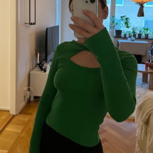 Grön topp med cutout - Tunnare grön stickad tröja med cutout över bröstet från Gina Tricot. Aldrig använd. Storlek XS. 75:- ex frakt. 