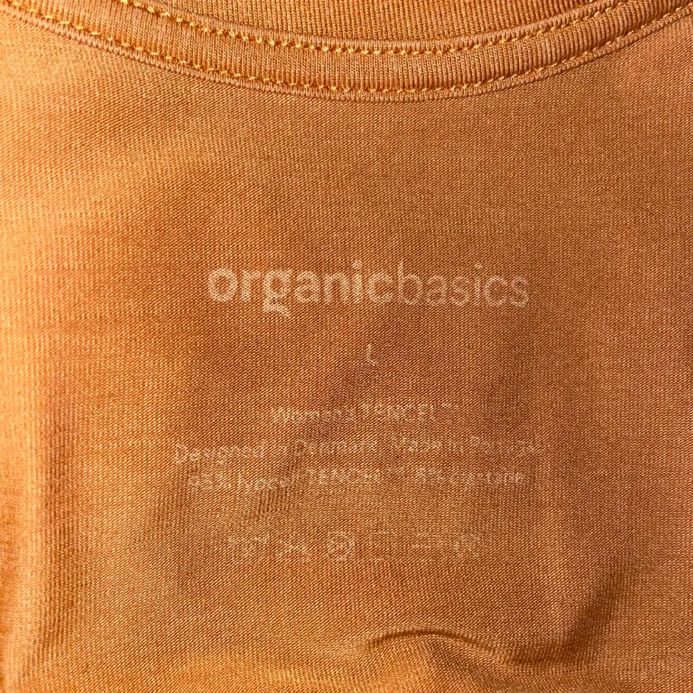 Lös ochre-färgad klänning från Organic Basics. Mjukt material, sällan använd. Når knäna. Passar upp till XL. Klänningar.