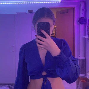 Blå fest top/blus  - Säljer en blå croppad festtop i silke från newyorker som jag aldrig använt bara testat. Från newyorker 