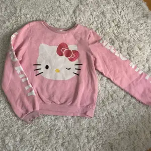 Hello kitty tröja, uppskattad storlek XS. Står hello kitty på båda armarna. Använd köp nu, garanterad snabb postning