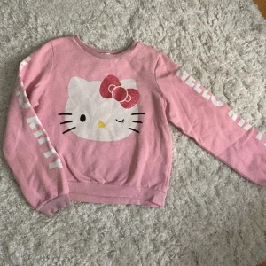 Hello kitty tröja - Hello kitty tröja, uppskattad storlek XS. Står hello kitty på båda armarna. Använd köp nu, garanterad snabb postning