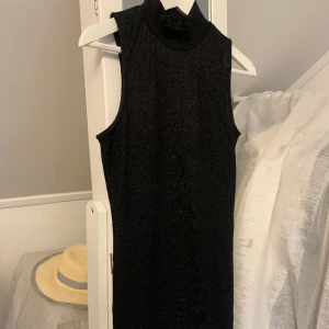 Glittrig klänning - Svart, glittrig klänning med polo krage. Bodycon med stretch