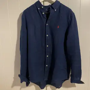 Säljer denna populära mörkblåa linneskjorta från Ralph Lauren | Använd lite grann men i bra skick | Storlek XL i barnstolek så jag skulle rekommendera att man är max 170 cm och stor runt midjan för att den ska passa så bra som möjligt | Nypris: 1400 kr | 