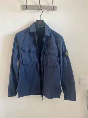 Stone Island overshirt/tunn jacka - Jag säljer nu min Stone Island overshirt/tunn jacka för att den är för liten för mig. Jackan är M men kan även passa L då den är precis för liten för mig och jag har L. Skicket är 9/10 då den bara används ett fåtal gånger. Priset är inte hugget i sten!!