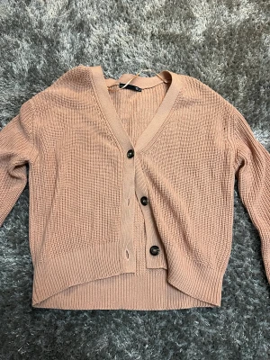 Stickad rosa kofta - Säljer en rosa stickad kofta med knappar från Lager 157 i storlek medium. Aldrig använd, köparen står för frakten 