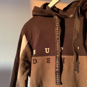 Hoodie - Svart och grön hoodie från supply demand