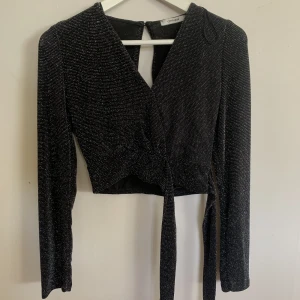 Glittrig topp från chiquelle  - Svart glittrig topp från chiquelle med knytning på sidan. 