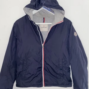 Moncler vindjacka  - Hej! Säljer nu min moncler vindjacka då den inte passar mig längre. Inga skador eller fläckar. Den e skön på sommar kvällar och när det är blåsigt. Skriv till mig vid mer info!