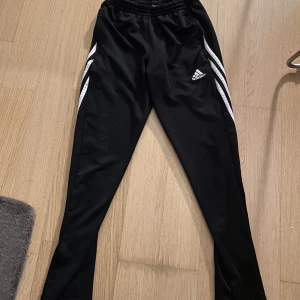 Adidas byxor  - Sänkt pris!! Adidas träningsoverallbyxor i Storlek 152, men jag som är XS kan ha dem och de sitter bra:) Kan skicka mått privat. Använda ca 10 gånger, fint skick! Enda ”skavanken” är den lilla ”slitning”/tyg på bild. 