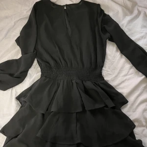 Klänning - Fin svart klänning i bra skick! Har volanger längst ner som gör att den får lite volym 