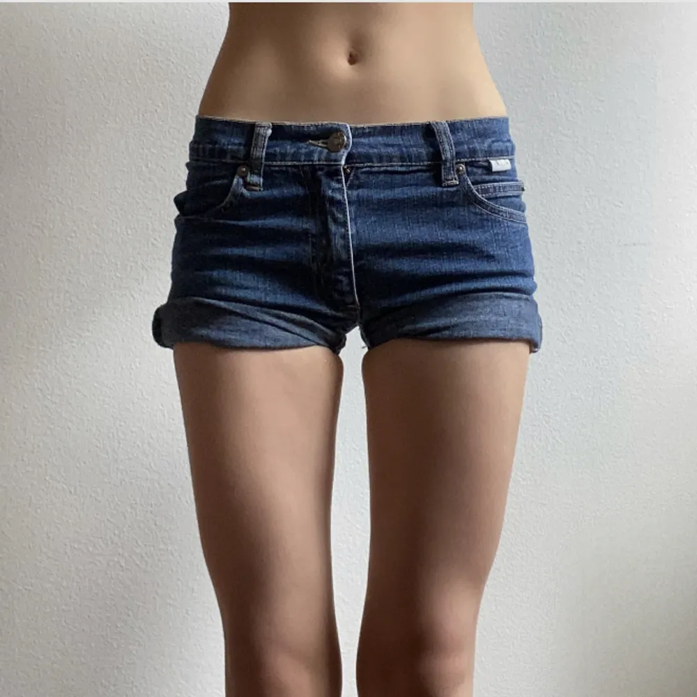 Avklippta jeans som är omgjorda till jeansshorts. Midjemått: 67 cm. Längd när de inte är uppvikta: 28 cm. Inte så stretchiga. Någon enstaka sliten sömm. . Shorts.