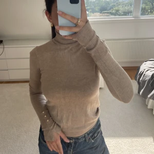 Beige polotröja från Zara - Beige tröja med polokrage från zara, guldiga detaljer vid ärmarna💖