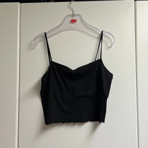 Svart linne med spagettistraps - Svart linne från HM med spagettistraps 🖤 Ribbat tyg med mycket stretch och sedan även med krusad detalj 🌑