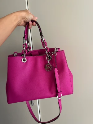 Helt ny rosa MK väska äkta  - Äkta Michael Kors väska i rosa  Helt oanvänd  Justerbar handtag använd som handväska eller över axeln  Massa små fack inuti 