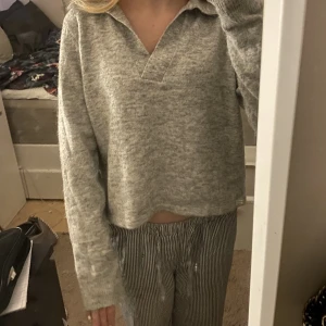 V-krage grå tröja ifrån about you - En grå stickad v-urringad tröja med krage ifrån about you ”flavia” i storlek M men passar mig perfekt som har xs/s. Använd fåtal gånger, har inga hål eller annat💗 (nypris 325kr)