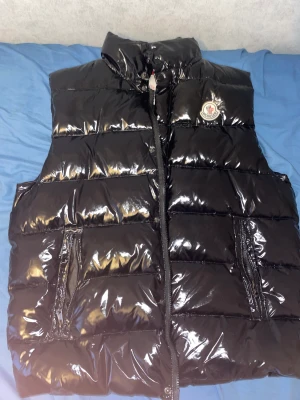 Moncler väst  - Har använt den i en månad den e ny fast lite sönder där bak 