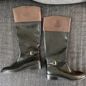 Skinnstövlar Ralph Lauren stl 37 som nya !  - Snygga skinnstövlar Ralph Lauren aldrig använda i svart skinn med brun överdel. Inpräglat RL i överdel stöveln , klackhöjd 2,5cm. Inköpt på Boozt 2000:-  Lycka till 🌸