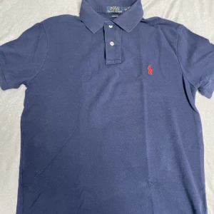 Ralph Lauren piké - En sjukt snygg marinblå pike från Ralph Lauren. Inga synliga defekter, och kragen, loggan är vid hög kvalite. Storleken är S. Skriv vid frågor ⭐️