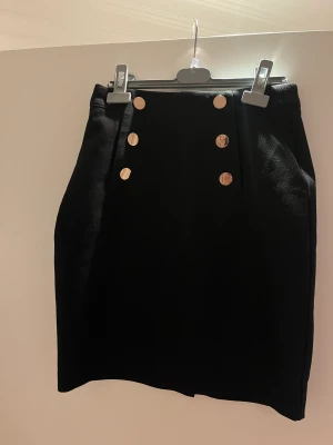 Kjol - Svart kjol med gulddetaljer 