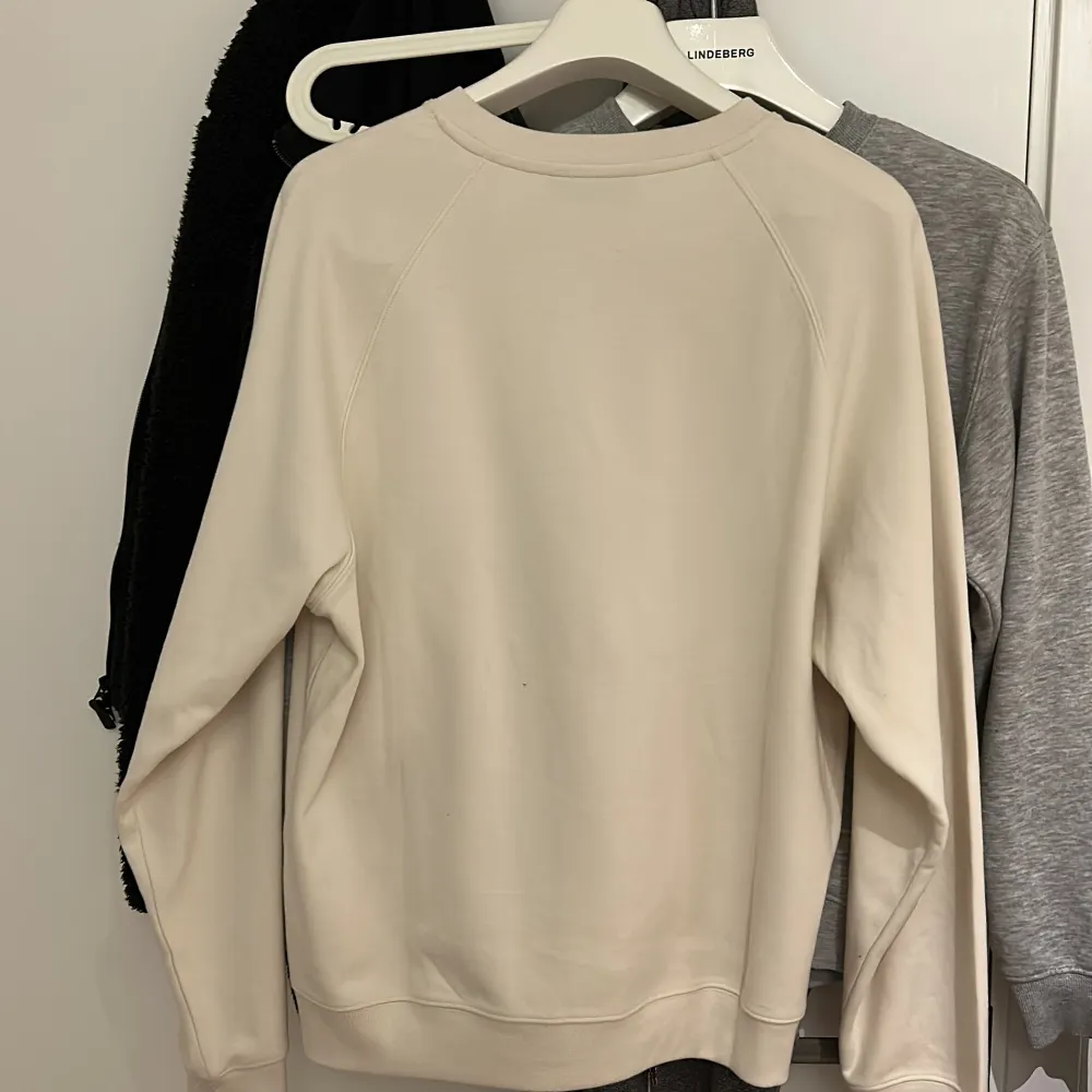 En krämvit / beige sweatshirt från j.lindeberg som sitter oversized på en S men lagom till en M. Tröjor & Koftor.