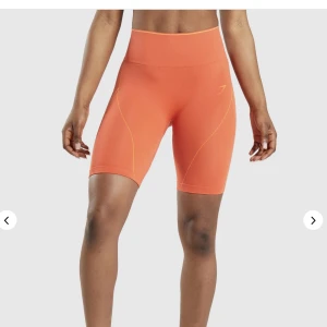 Gymshark shorts - Säljer ett par orangea gymshark shorts i strl S, sparsamt använda men finns ett super litet hål i sömnen som ni kan se på bild två, det är inget som syns när man har dem på sig men bara så att man vet det, slutsålda på hemsidan 