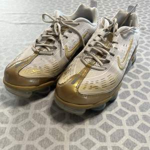 Vita Nike Vapor Max 360 sneakers med gulddetaljer i storlek 40. Knappt använda och säljer då de inte passar mig. 