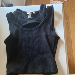 Svart ribbad T-shirt med hål över bröstet  - Från Hm, storlek Xs, Fri frakt