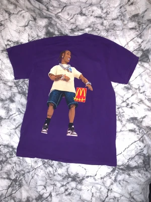 Travis Scott McDonalds t-shirt - Den har bara använts 1 gång förut. Den har en fabriksdefekt som fanns där när jag fick den, därför sänkt pris. Det syns dock inte från utsidan när man har på den. Storleken är Small och passar true to size. Kvitto finns. Hör av er om ni undrar något!