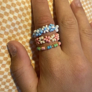 Ribgar - Supersöta handgjorda ringar, perfekt till sommaren! Ca 1-1,5cm. Har limmat ihop pärlorna på tråden, så de borde hålla bra. Skickar med postnords frakt 15kr. 