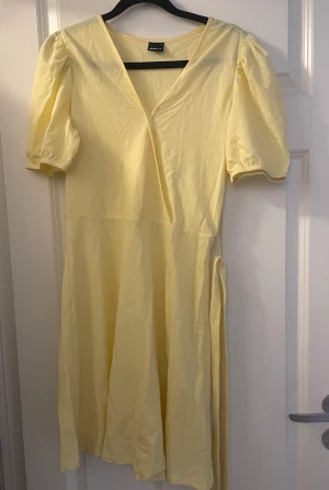 Klänning - Gul jättefin gul klänning med knyte runt midjan, går till knäna och är nästan oanvänd 💗