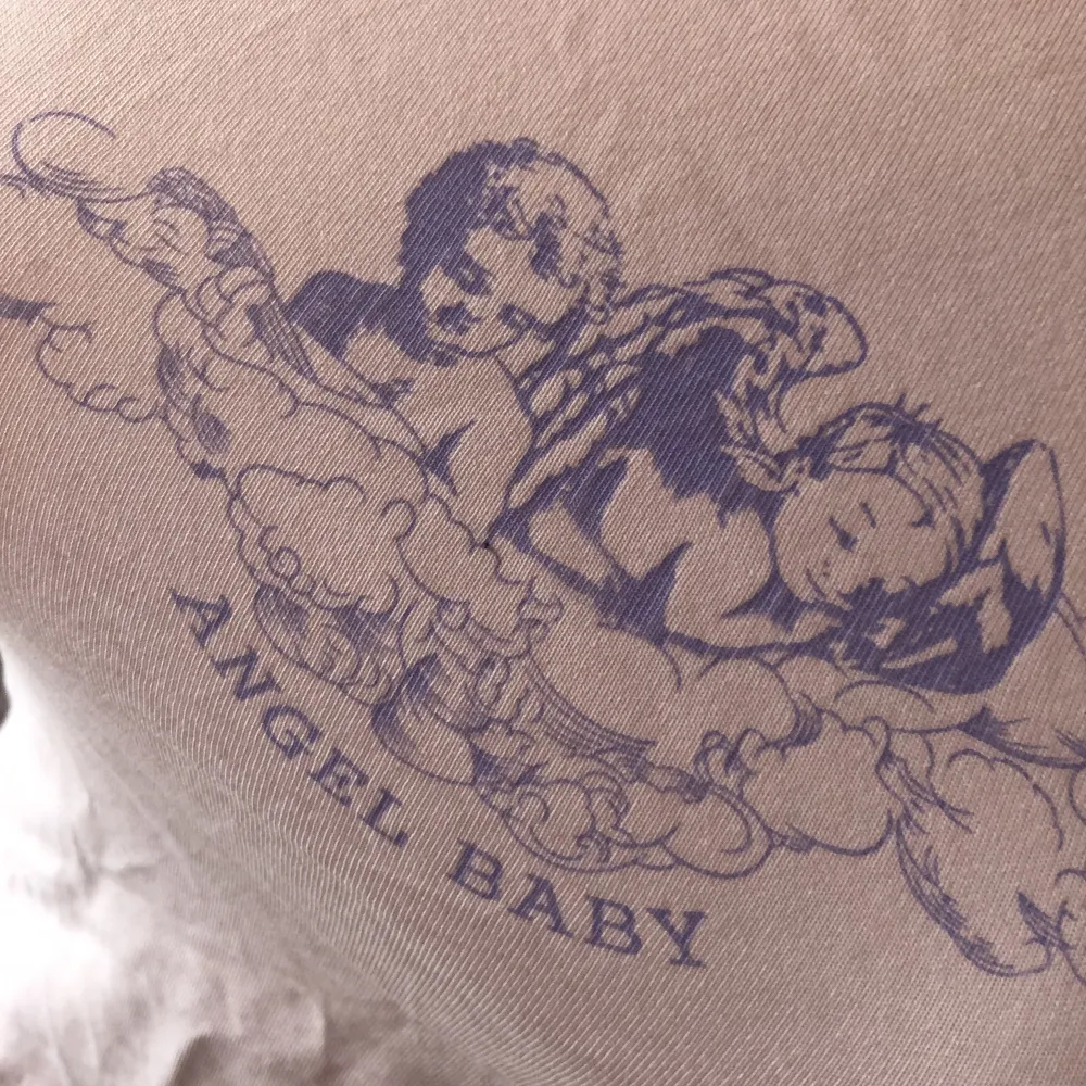 Baby Tee med tryck av änglar. T-shirts.