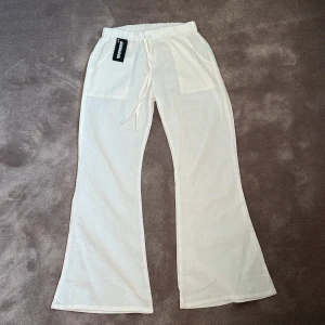 Vita linnebyxor - Krämvita linnebyxor, utsvängda. Aldrig använda, nyskick med lapp kvar. Köpta för 255kr.