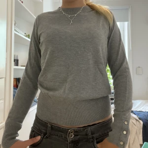 Grå stickad tröja - Grå stickad tröja från Lindex men knapp detaljer