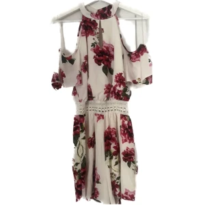Krämvit playsuit med blommor  - Krämvit playsuit med rosa blommor och spets i midjan, slutar relativt högt upp på låren (beroende på längd) använd en gång, bra skick, prutbart pris 