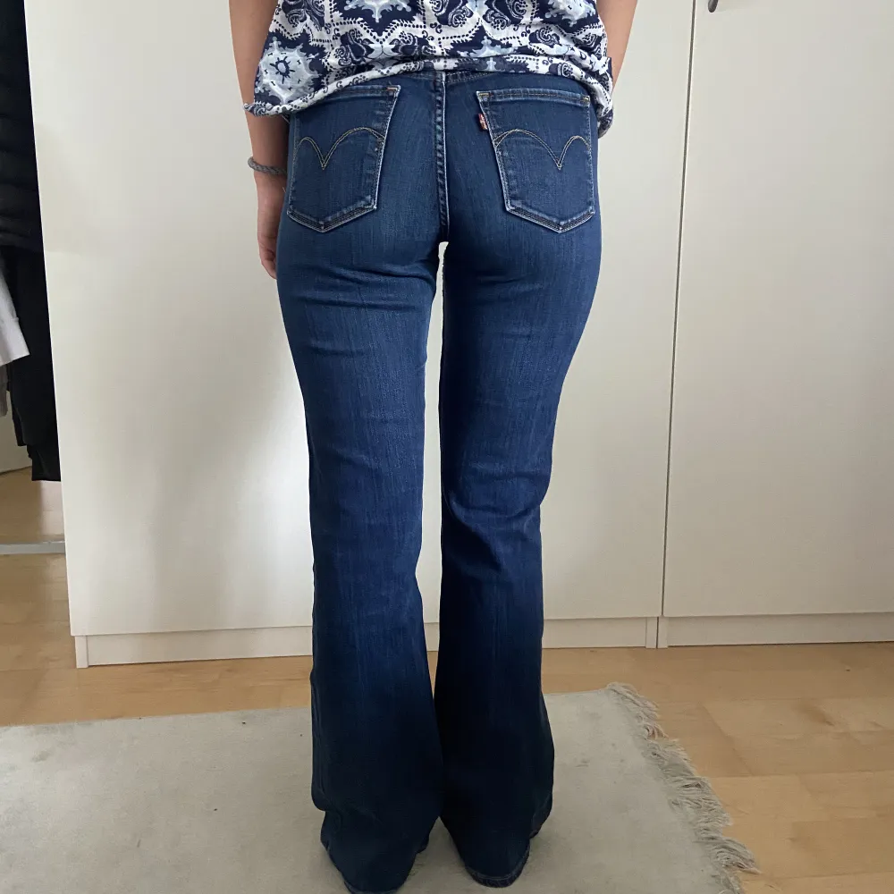 Lågmidjade bootcut levi’s jeans i en mörkblå färg. Modellen är 165cm lång. . Jeans & Byxor.
