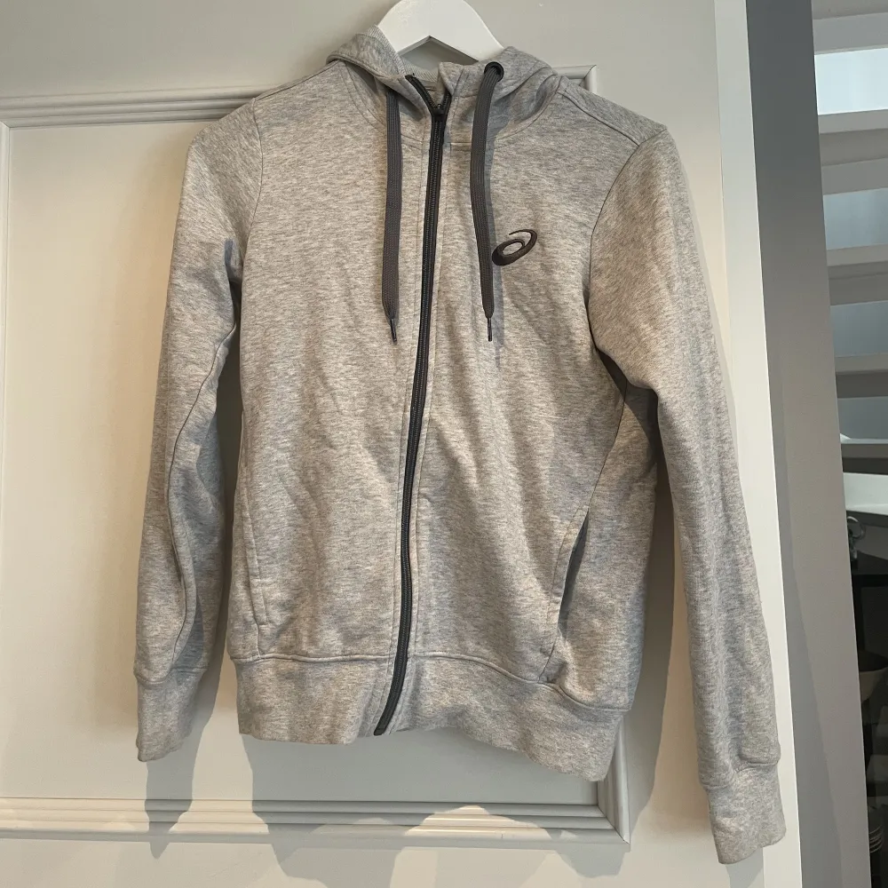 En grå asics zip-hoodie och är i storlek S. Använd fåtal gånger säljer för 150 kr + frakt. Köpte tröjan för 499 kr. . Hoodies.