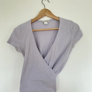 Topp - En ljuslila topp från Monki i storlek XS med knytning. Skitsnygg men tyvärr lite liten för min del. 